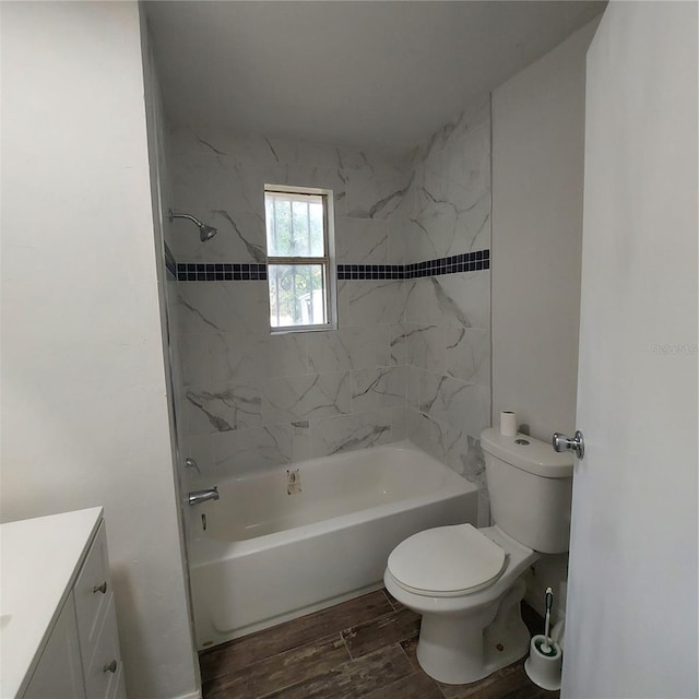 full bathroom featuring vanity, hardwood / wood-style flooring, toilet, and tiled shower / bath combo