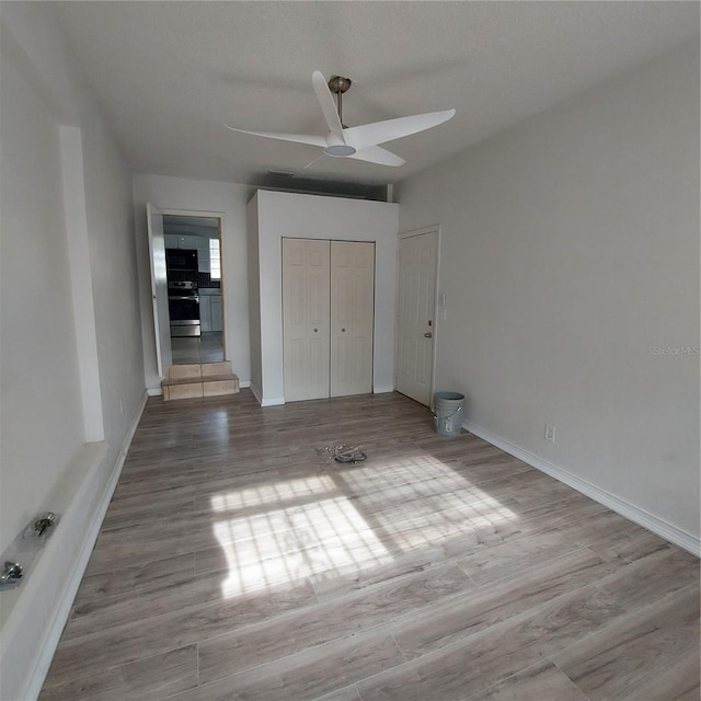 unfurnished bedroom with a closet, light hardwood / wood-style floors, and ceiling fan