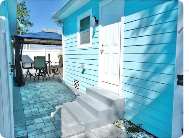 view of side of property featuring a patio area and a gazebo