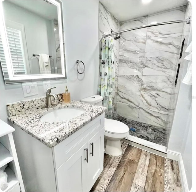 bathroom with vanity, toilet, curtained shower, and wood-type flooring