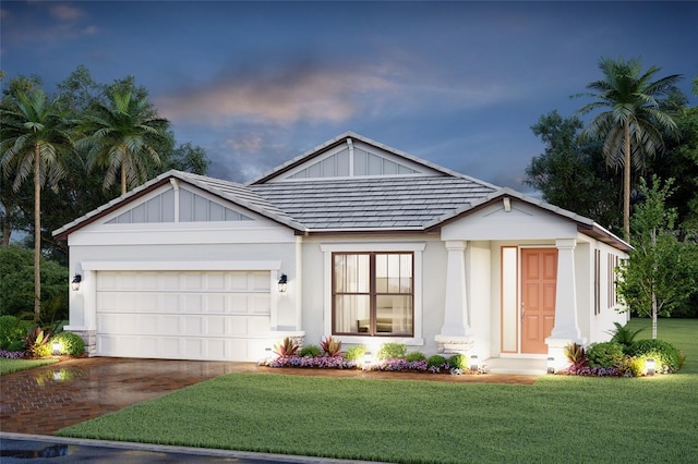 view of front of property featuring a garage and a lawn