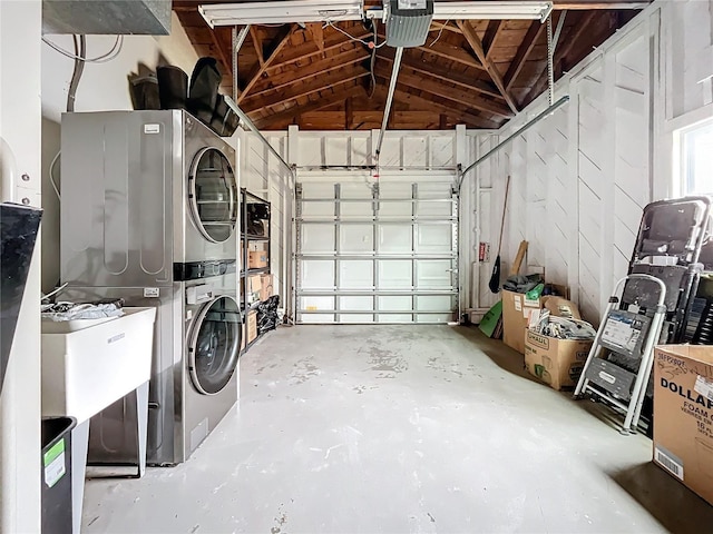 garage with a garage door opener and stacked washer / drying machine