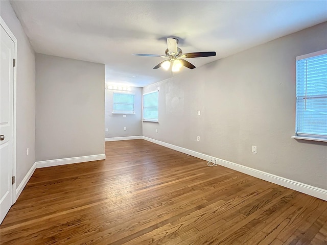 empty room with ceiling fan and dark hardwood / wood-style flooring