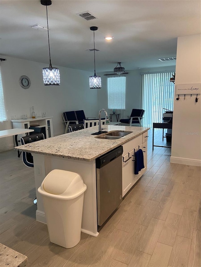 kitchen with sink, a kitchen island with sink, white cabinetry, decorative light fixtures, and stainless steel dishwasher