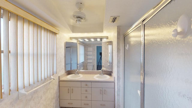 bathroom featuring a shower with door and vanity