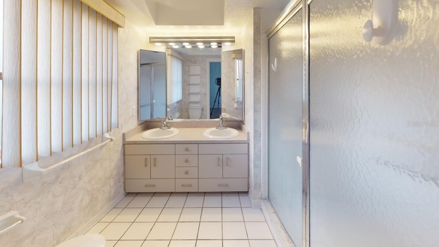 bathroom featuring tile patterned flooring, vanity, toilet, and walk in shower