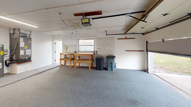 garage featuring a garage door opener, electric water heater, and heating unit