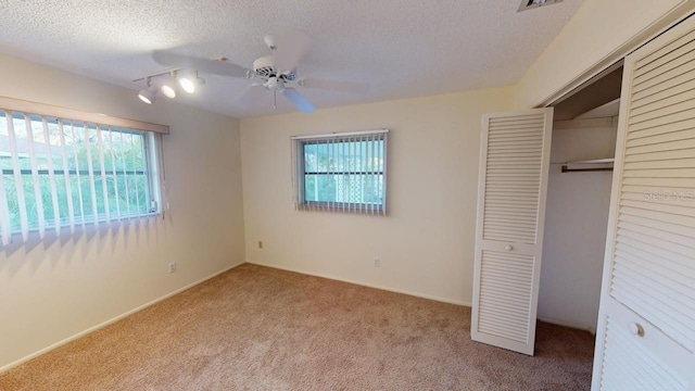 unfurnished bedroom featuring a closet, multiple windows, and a textured ceiling