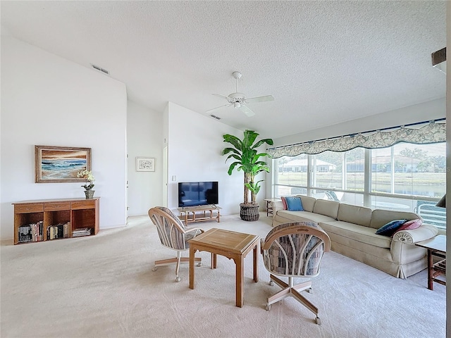 carpeted living room featuring a textured ceiling, vaulted ceiling, and ceiling fan