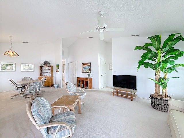 carpeted living room with ceiling fan, a textured ceiling, and high vaulted ceiling