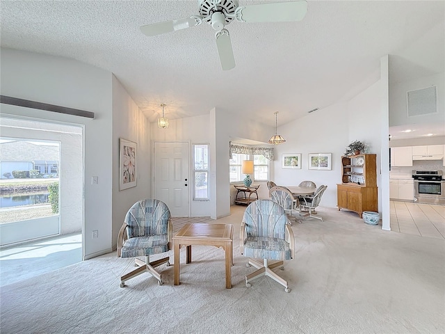 living room with ceiling fan, high vaulted ceiling, light colored carpet, and a textured ceiling