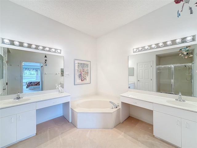 bathroom with vanity, shower with separate bathtub, and a textured ceiling