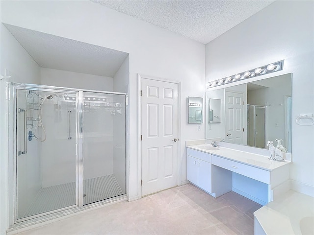 bathroom featuring vanity, an enclosed shower, and a textured ceiling