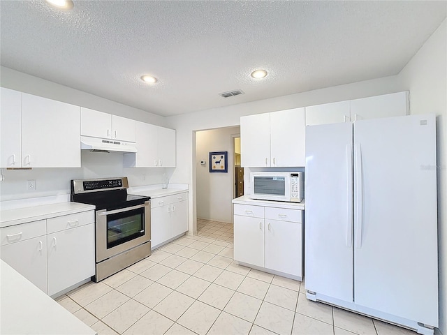 kitchen featuring white cabinetry, light tile patterned flooring, a textured ceiling, and white appliances