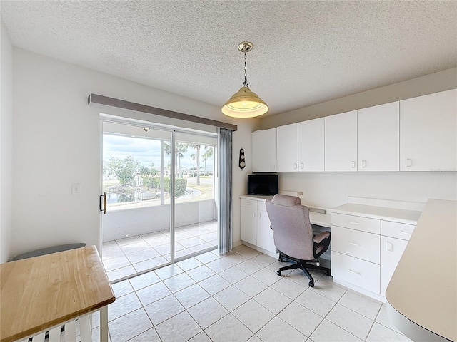 office area featuring light tile patterned floors, built in desk, and a textured ceiling