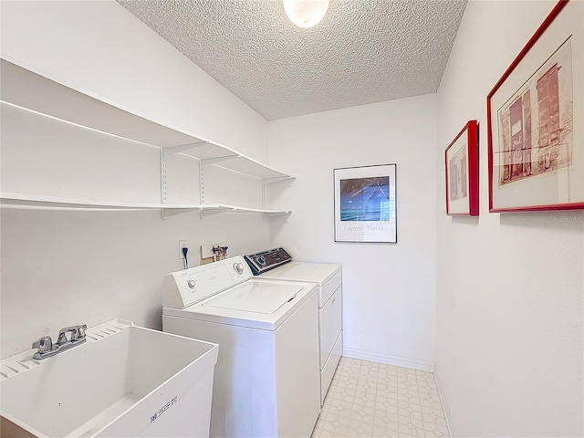 laundry room with separate washer and dryer, sink, and a textured ceiling