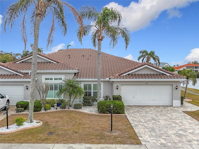 mediterranean / spanish house featuring a garage and a front yard