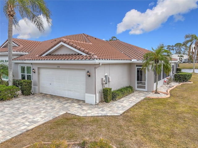 mediterranean / spanish house with a garage and a front lawn