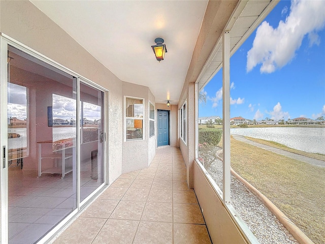 unfurnished sunroom featuring a water view and a healthy amount of sunlight