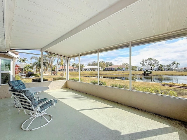 unfurnished sunroom with a water view and vaulted ceiling with beams