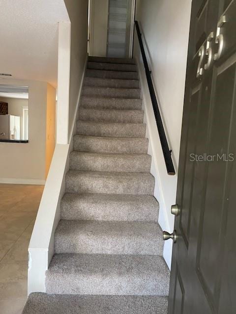 stairs featuring tile patterned floors