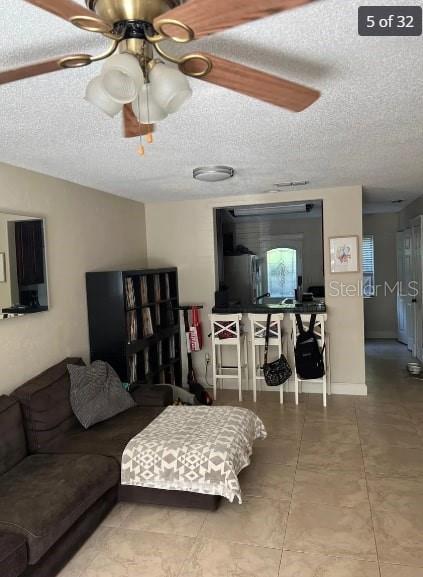 living room with a textured ceiling and ceiling fan