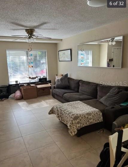 living room featuring ceiling fan, plenty of natural light, and light tile patterned floors