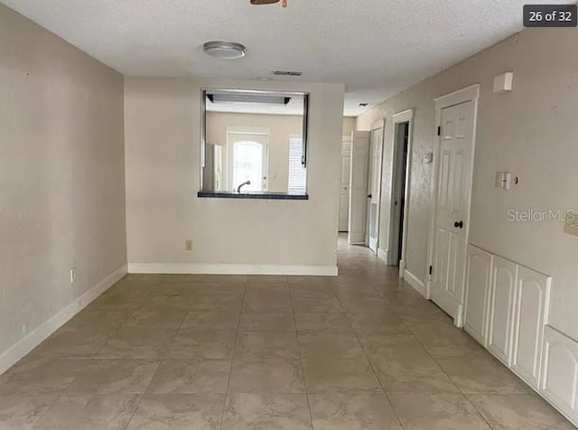 hall featuring a textured ceiling