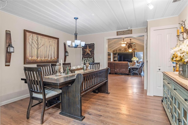 dining area with crown molding, a chandelier, and light hardwood / wood-style flooring