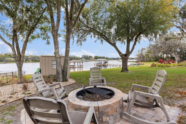 view of patio / terrace with a water view, a shed, and a fire pit