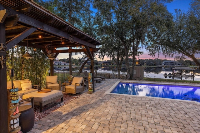 pool at dusk featuring an outdoor living space, a gazebo, a patio area, and a water view