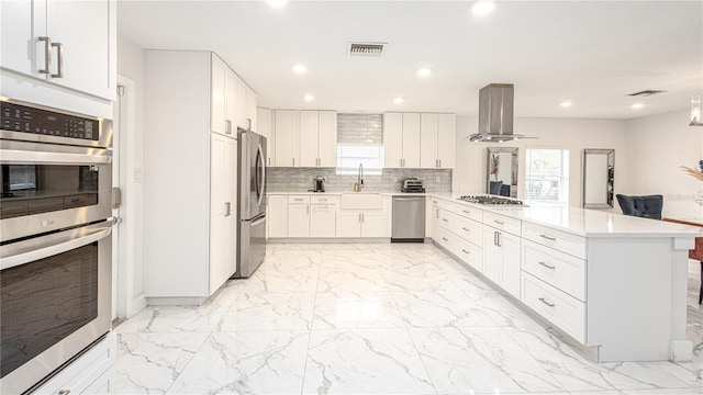 kitchen with tasteful backsplash, white cabinetry, sink, island exhaust hood, and stainless steel appliances