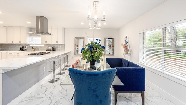 kitchen featuring extractor fan, decorative light fixtures, tasteful backsplash, white cabinets, and stainless steel gas cooktop