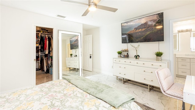 bedroom with ceiling fan, a walk in closet, ensuite bath, and a closet