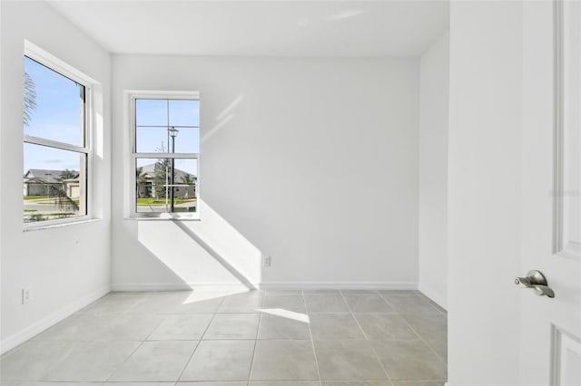 spare room with light tile patterned floors and a wealth of natural light