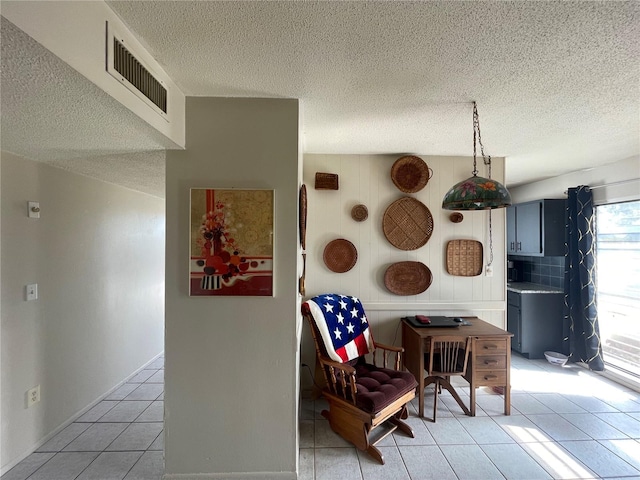 kitchen with a textured ceiling and light tile patterned floors