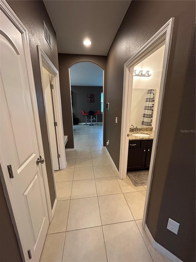 corridor with sink and light tile patterned flooring