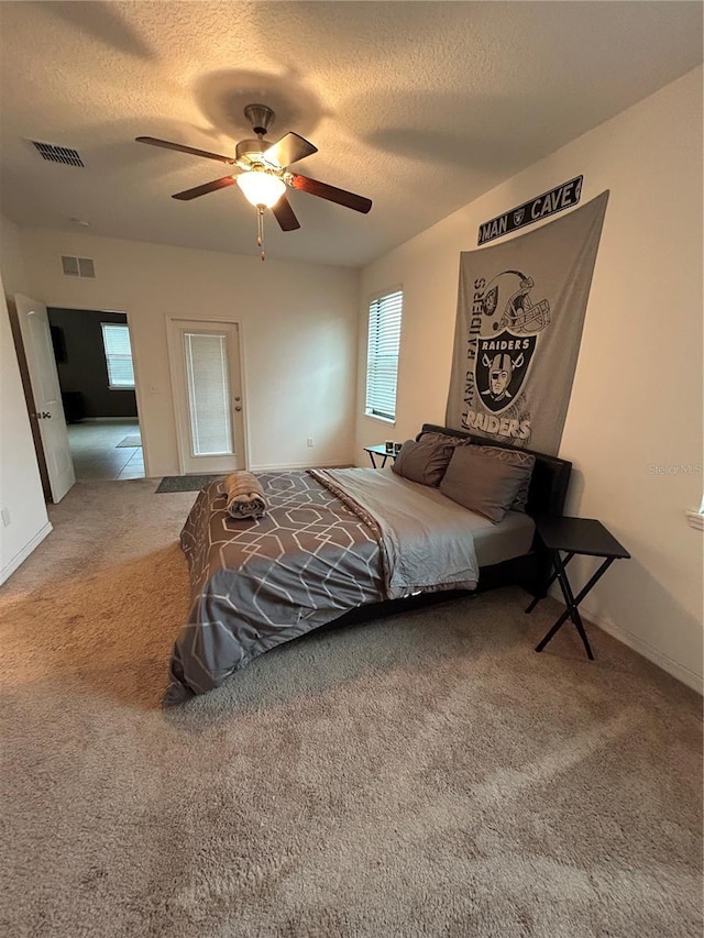 carpeted bedroom featuring a textured ceiling and ceiling fan