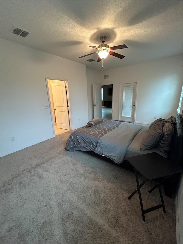 bedroom with a textured ceiling, ceiling fan, and carpet flooring