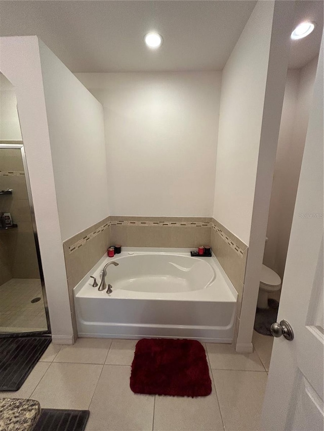 bathroom with tile patterned floors, independent shower and bath, and toilet