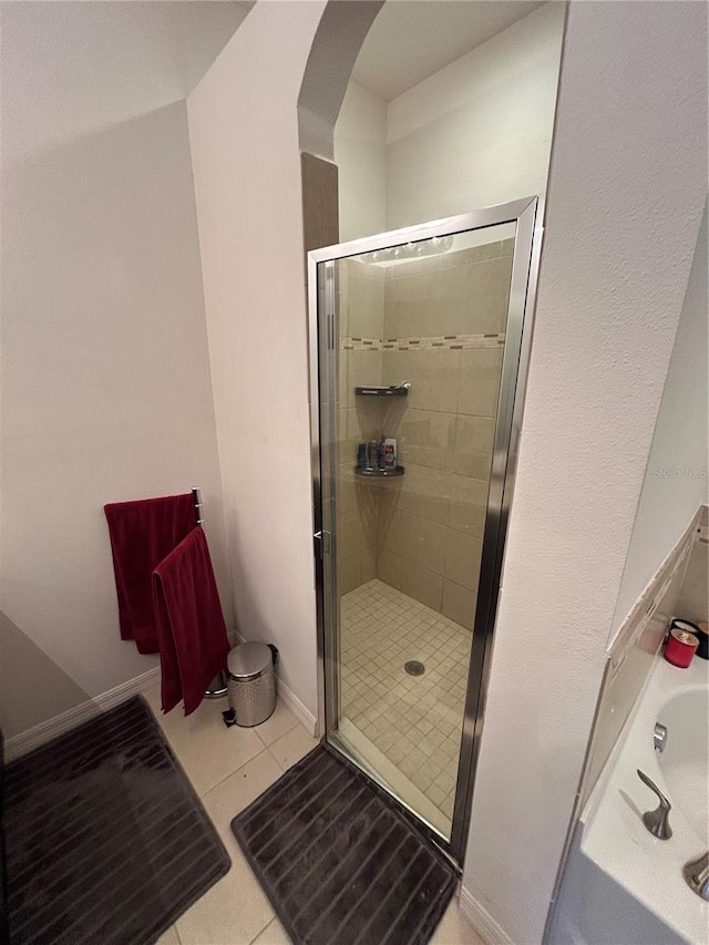 bathroom with tile patterned flooring and a shower with door