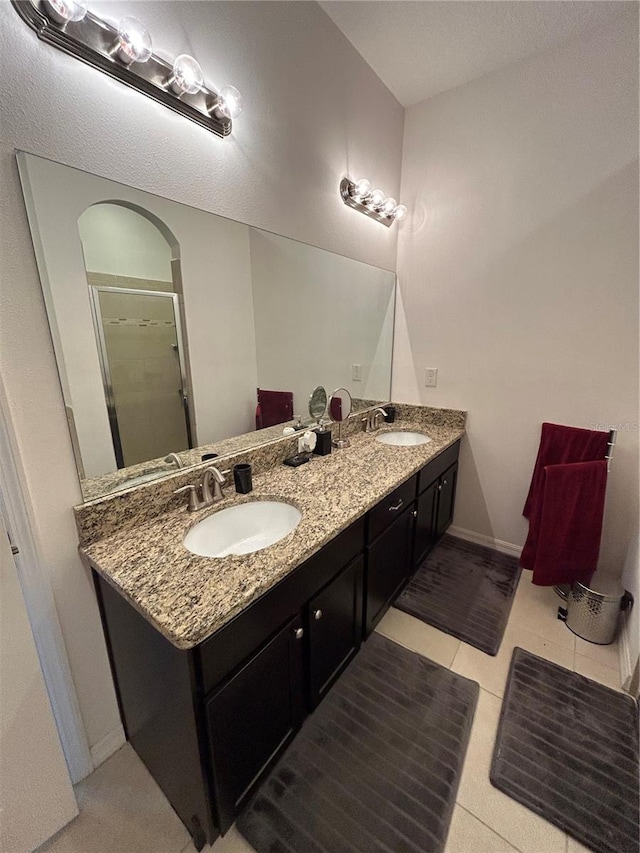 bathroom featuring tile patterned flooring, vanity, and a shower with door