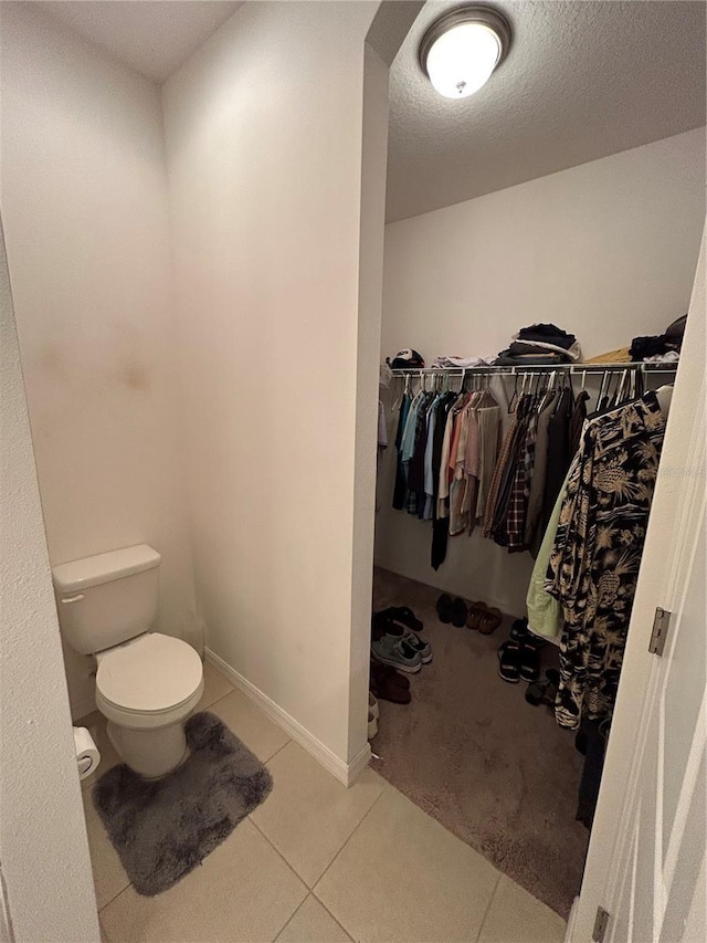 bathroom with tile patterned floors, a textured ceiling, and toilet