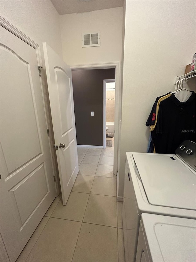 laundry area featuring light tile patterned floors and washer and dryer