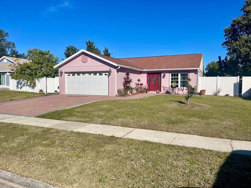 single story home featuring a garage and a front yard