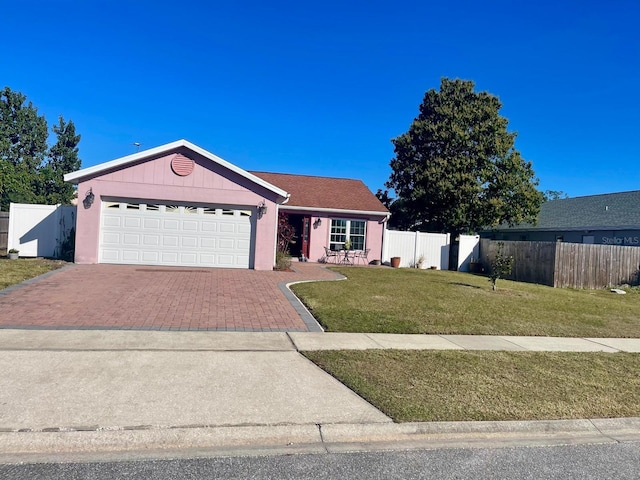 ranch-style house featuring a garage and a front lawn