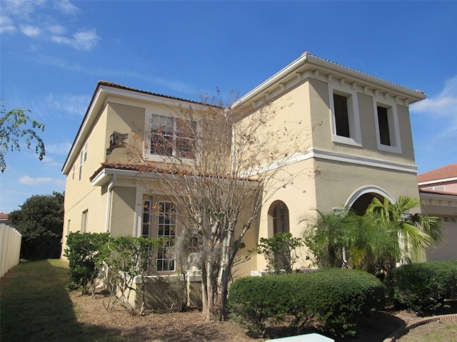 mediterranean / spanish-style home featuring stucco siding and fence