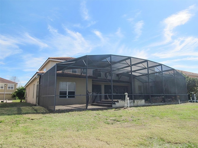 back of property featuring stucco siding, a patio, a lawn, and glass enclosure