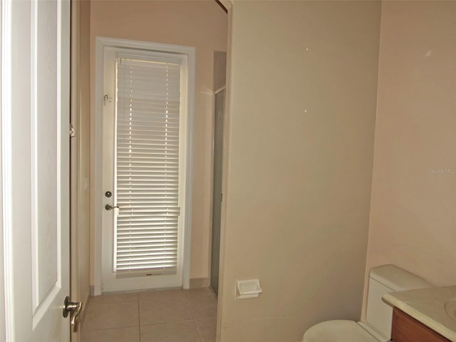 bathroom featuring vanity, tile patterned floors, toilet, and a shower with shower door