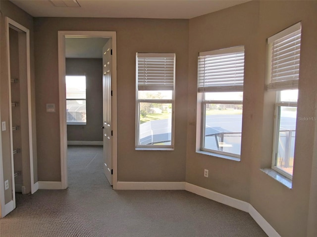 empty room featuring carpet and baseboards